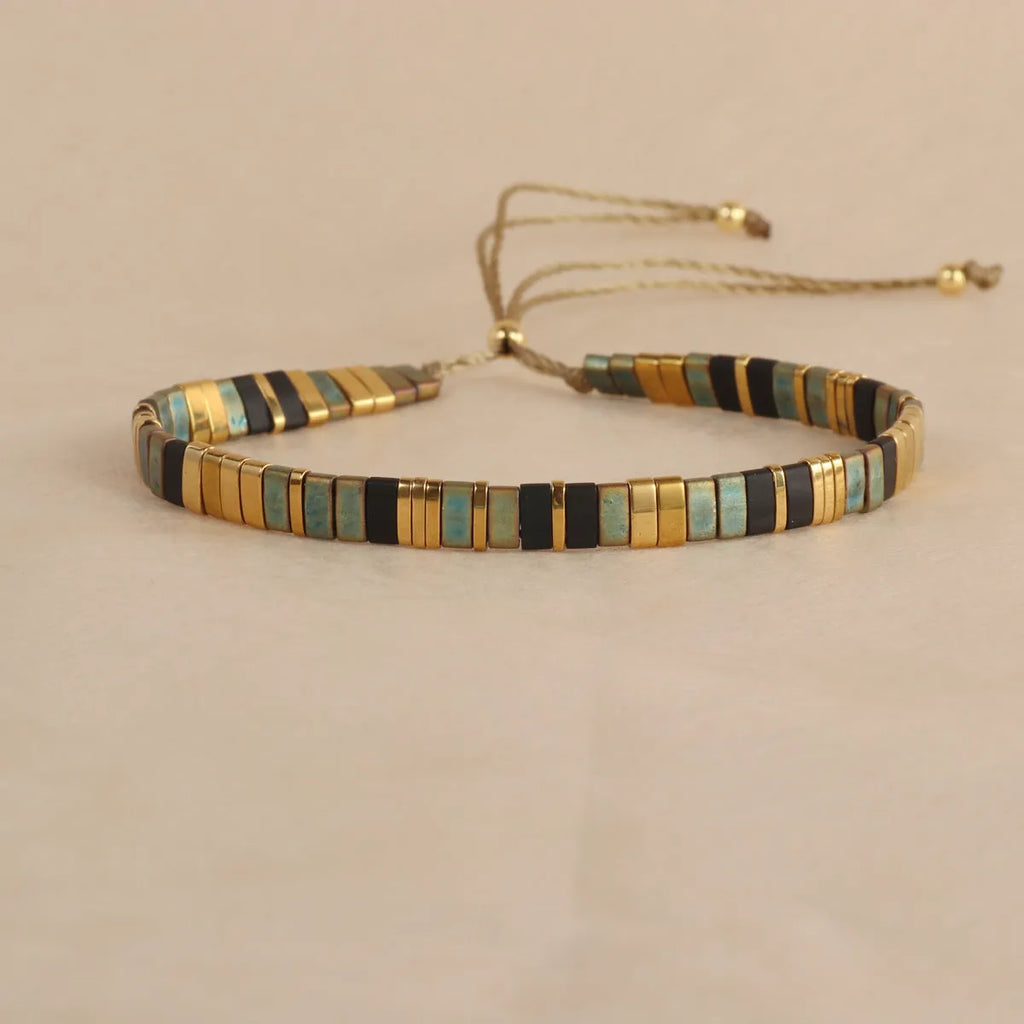 Geometric glass and coloured glaze beaded bracelet in milky white, black, green, blue, or red.