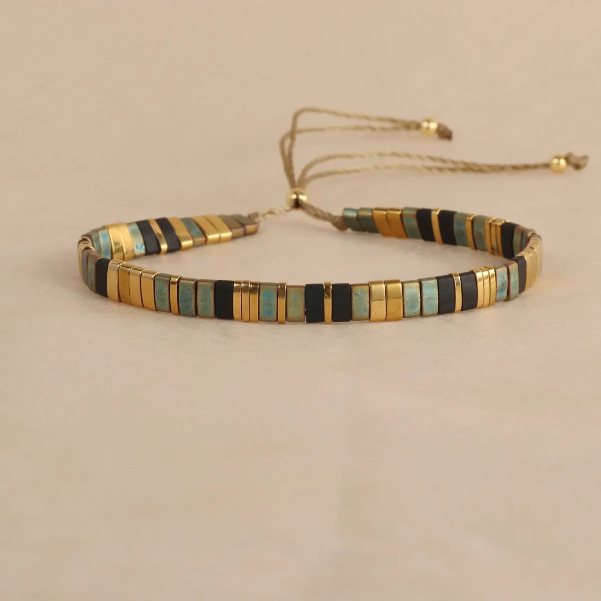 Geometric glass and coloured glaze beaded bracelet in milky white, black, green, blue, or red.