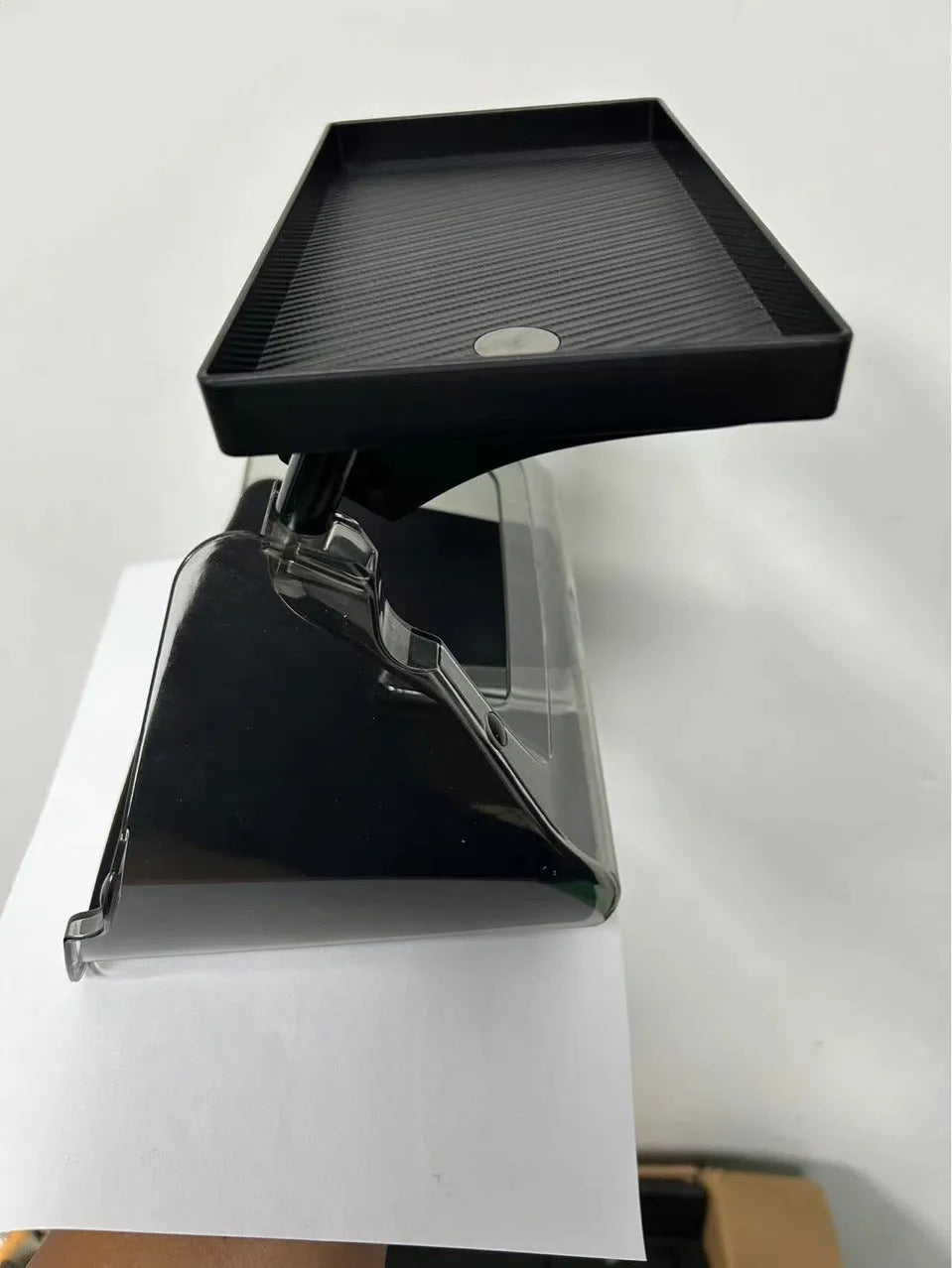 White ABS plastic storage box fitted under the screen of a Tesla Model 3 for small items