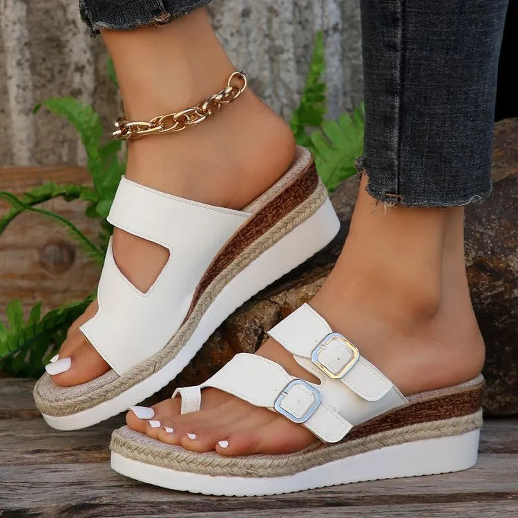White wedge heel sandals with woven patent leather upper and peep toe design
