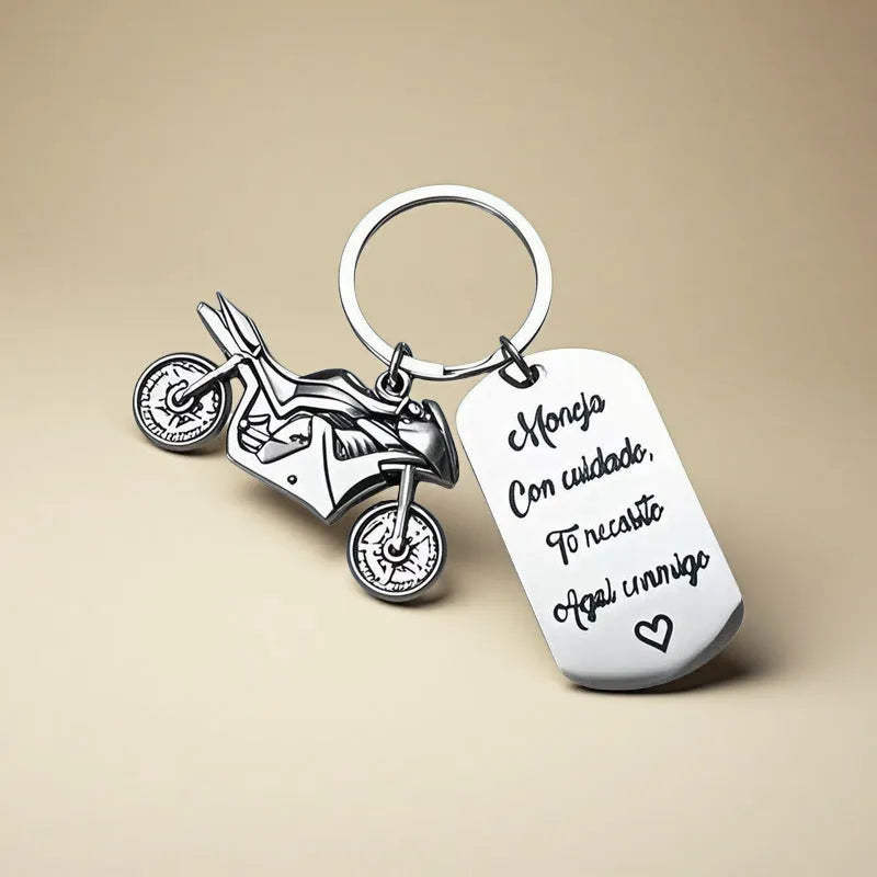 Stainless steel motorcycle-themed keychain with inspirational text alongside a flannel storage pouch.