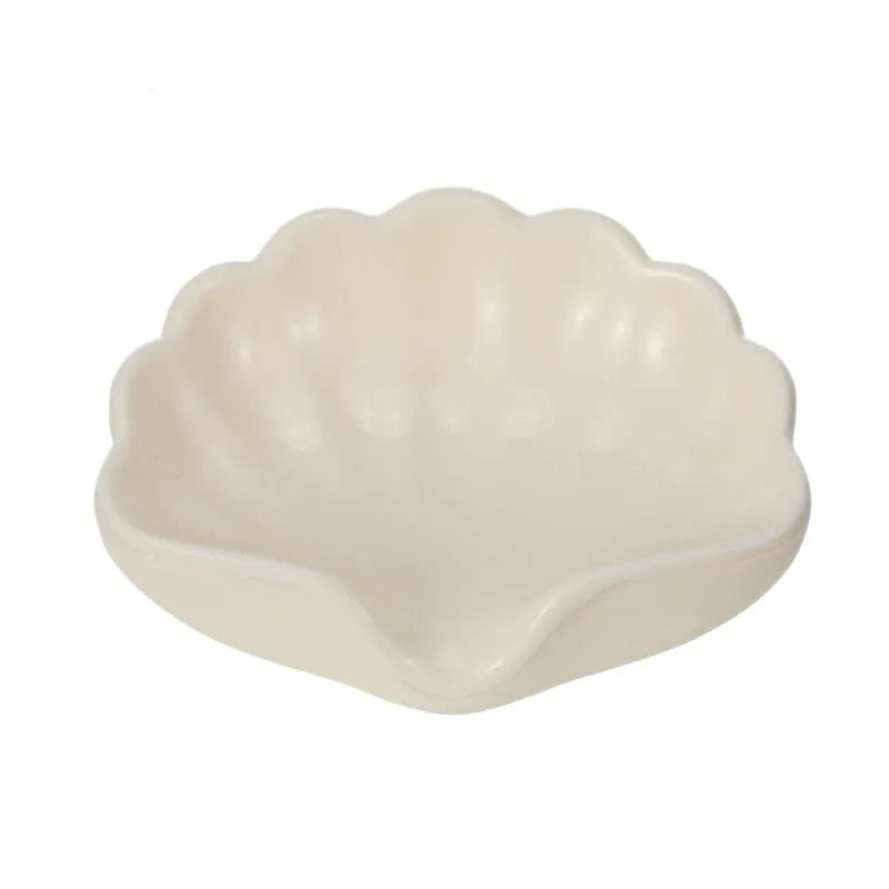 Pearl white plastic shell-shaped soap dish with drainage channels measuring 12cm long
