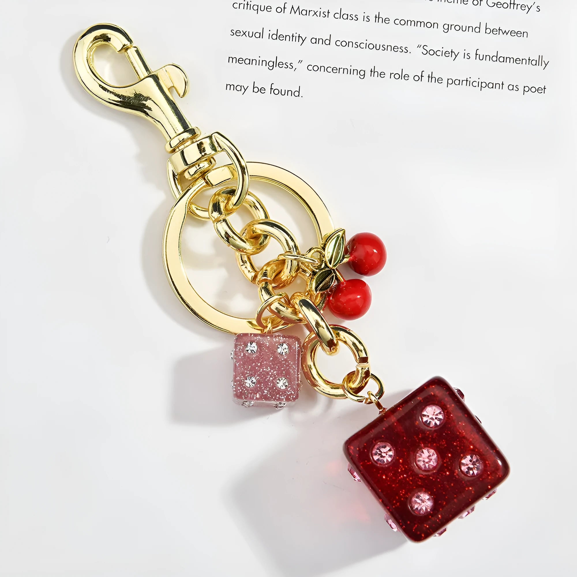Square metal keychain pendant with a vintage red and white cherry dice pattern.