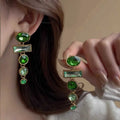 A pair of retro green gradient alloy earrings with geometric shapes and a long tassel design.