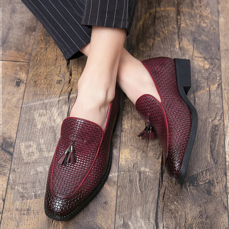 Men's black pointed toe slip on loafers with a tassel detail on the front.