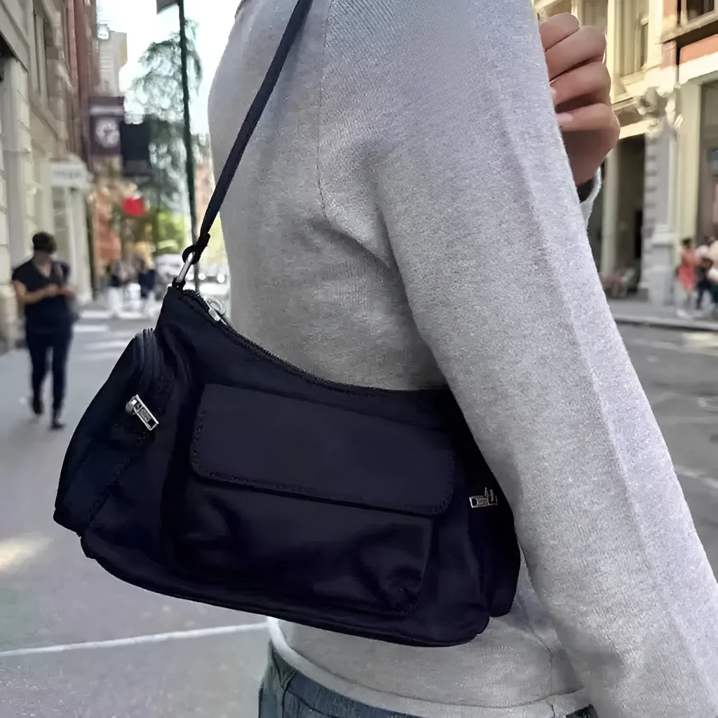 Black lightweight PU shoulder bag with two pockets and side-line detailing.