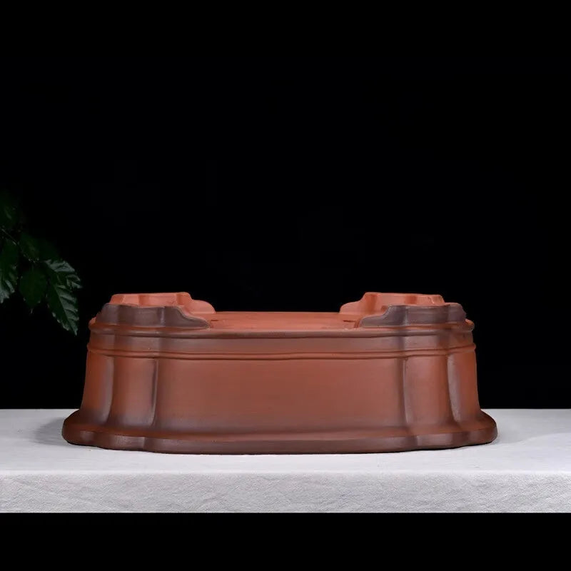 Antique-style purple clay flowerpot with Chinese decorative motifs showing tree stump, pine, cypress, pomegranate, golden marble, antique jade belt, and crabapple designs