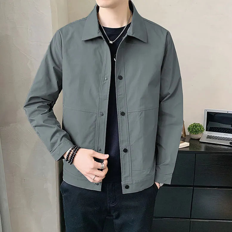Man wearing a thin, single-layer Korean-style jacket in light grey, showcasing long sleeves and a casual fit.