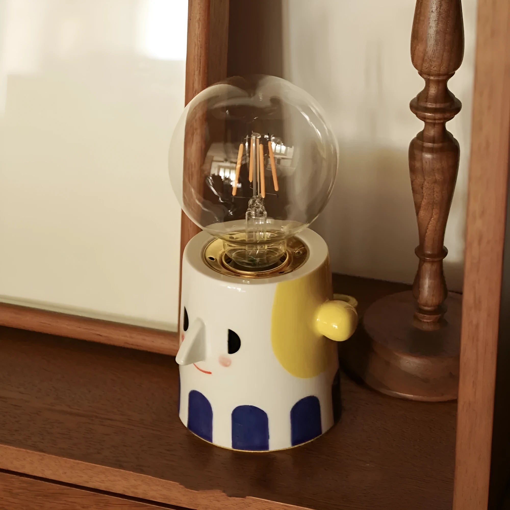 Handmade ceramic bedside lamp with spherical ball headlight shade on wooden nightstand