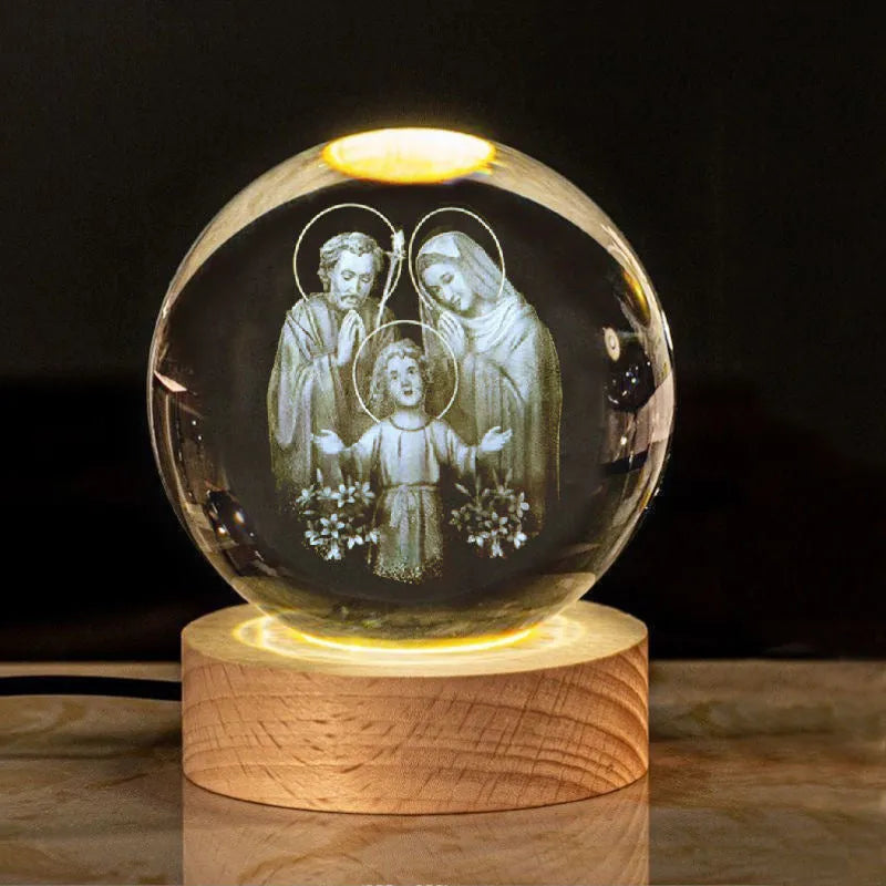 White crystal ball desk ornament with religious symbols on warm light wooden base