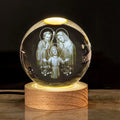 White crystal ball desk ornament with religious symbols on warm light wooden base