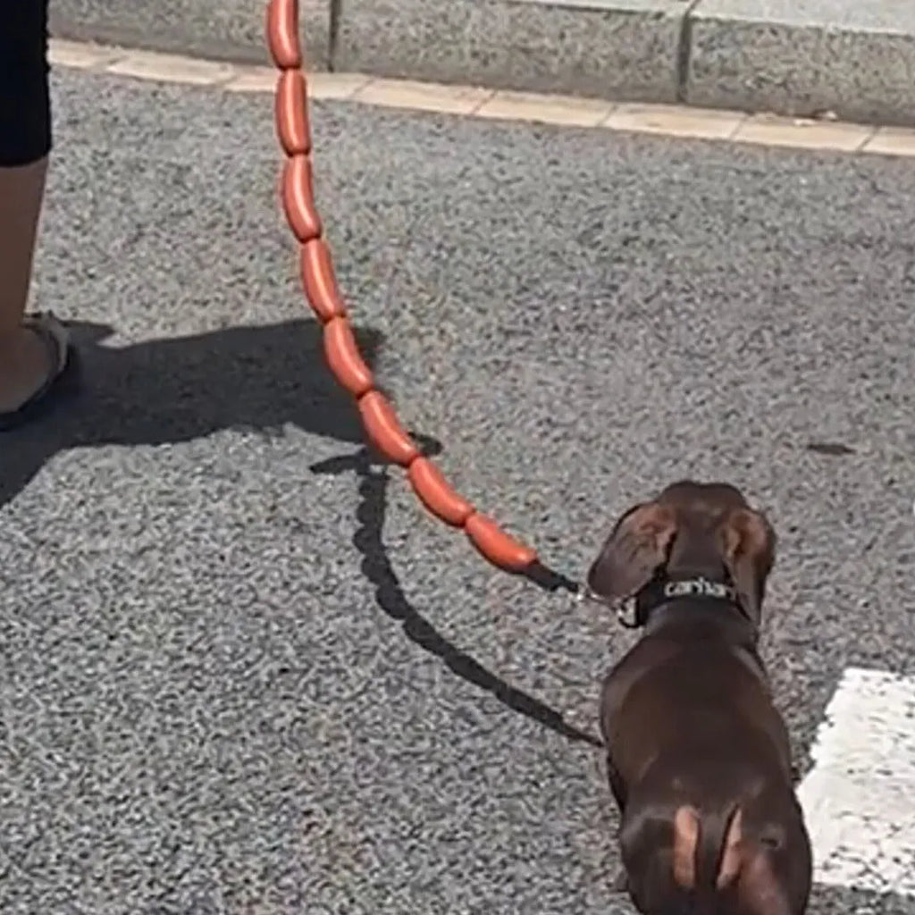 Brown three-section sausage rope toy 108cm long held by hand, pet tug and fetch rope