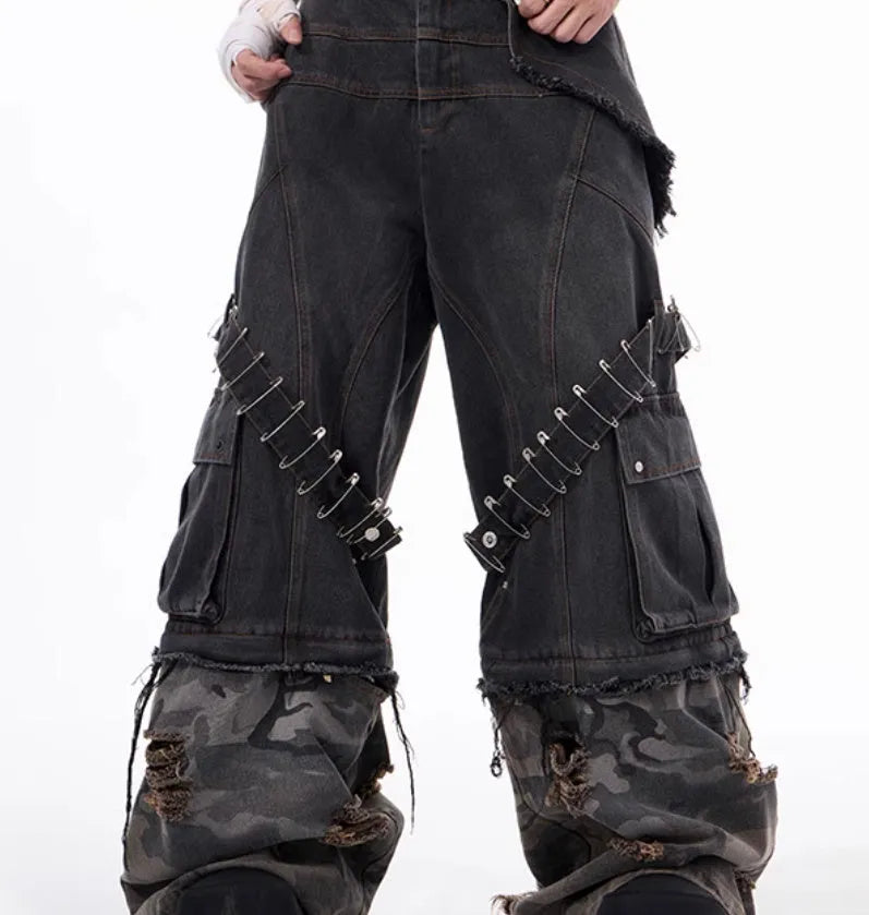 Men's grey cotton jeans with camouflage pattern splicing and decorative pin and ribbon details on the legs.
