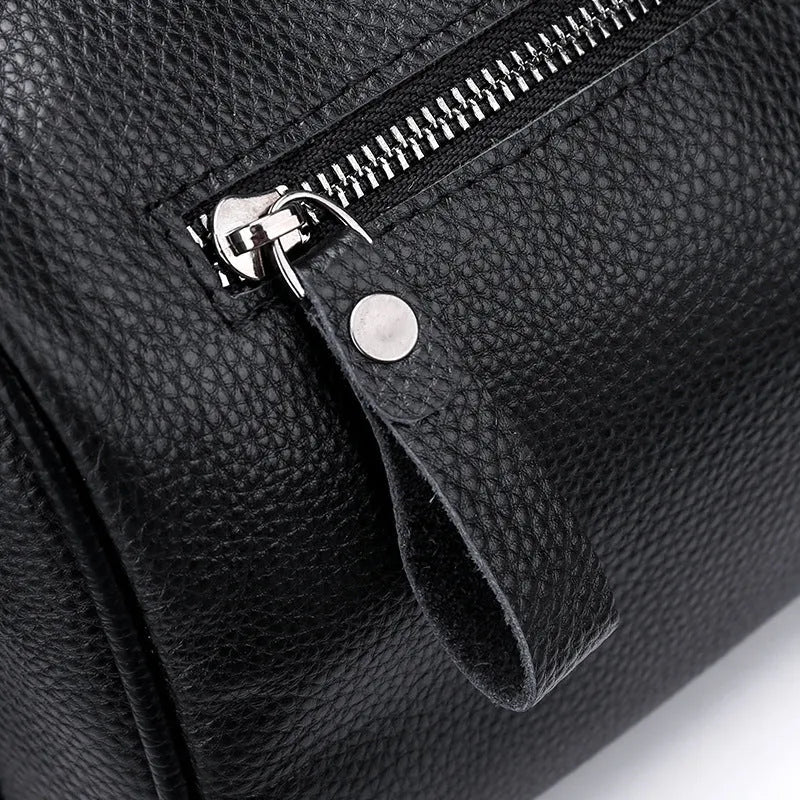 Black genuine leather crossbody bag with one shoulder strap showing interior polyester lining