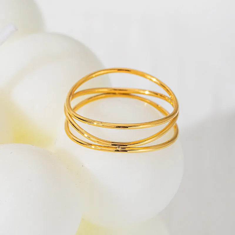 Gold titanium steel three-layer geometric line ring shown on finger, available in sizes No 5 to No 10