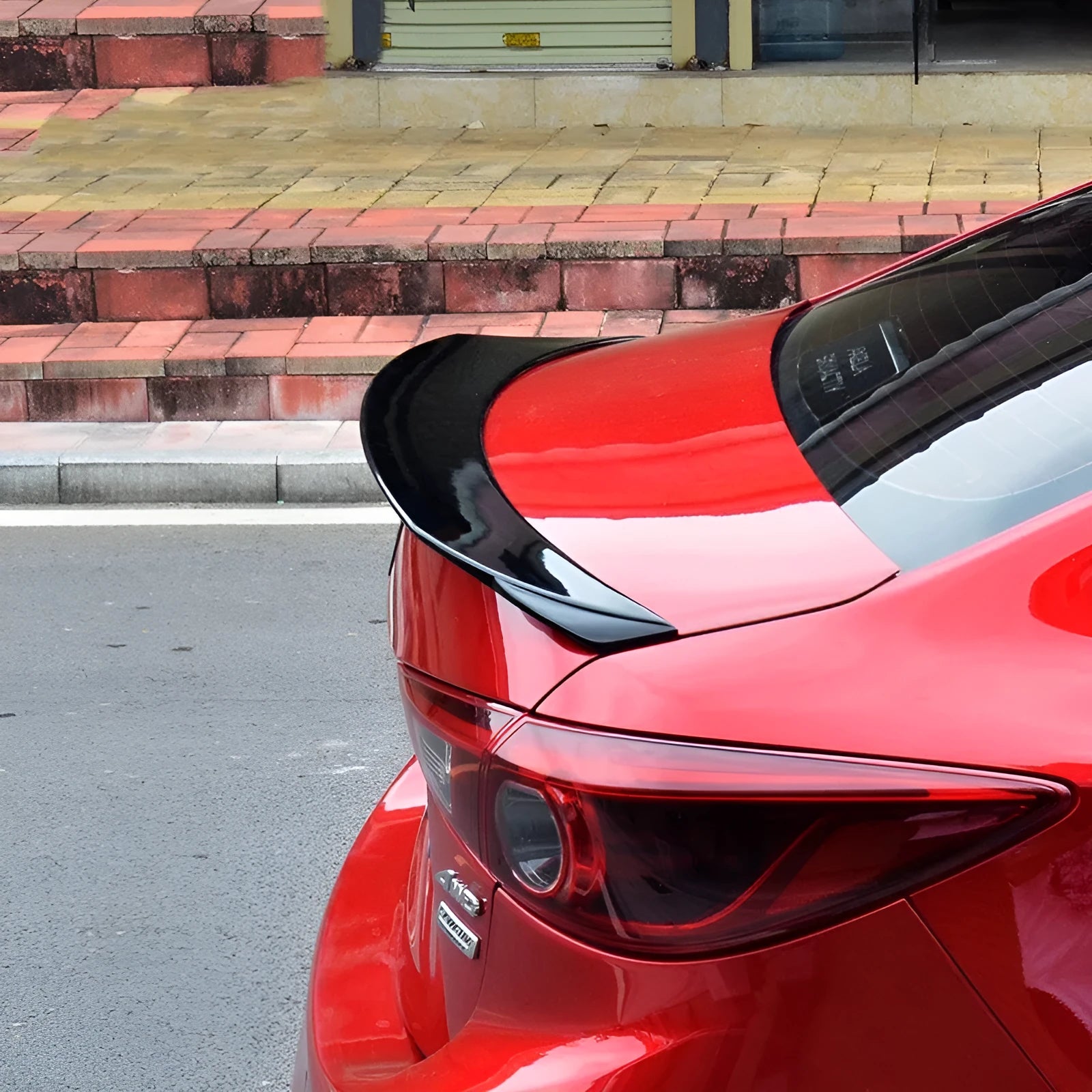 Large bright black tail blade spoiler for a Mazda 3 Axela car, showing wind-surrounded design.