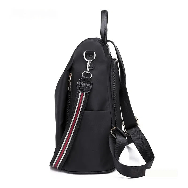 Women's large capacity black backpack with Oxford fabric lining, laptop sleeve, and trendy stitched seams and colour blocking