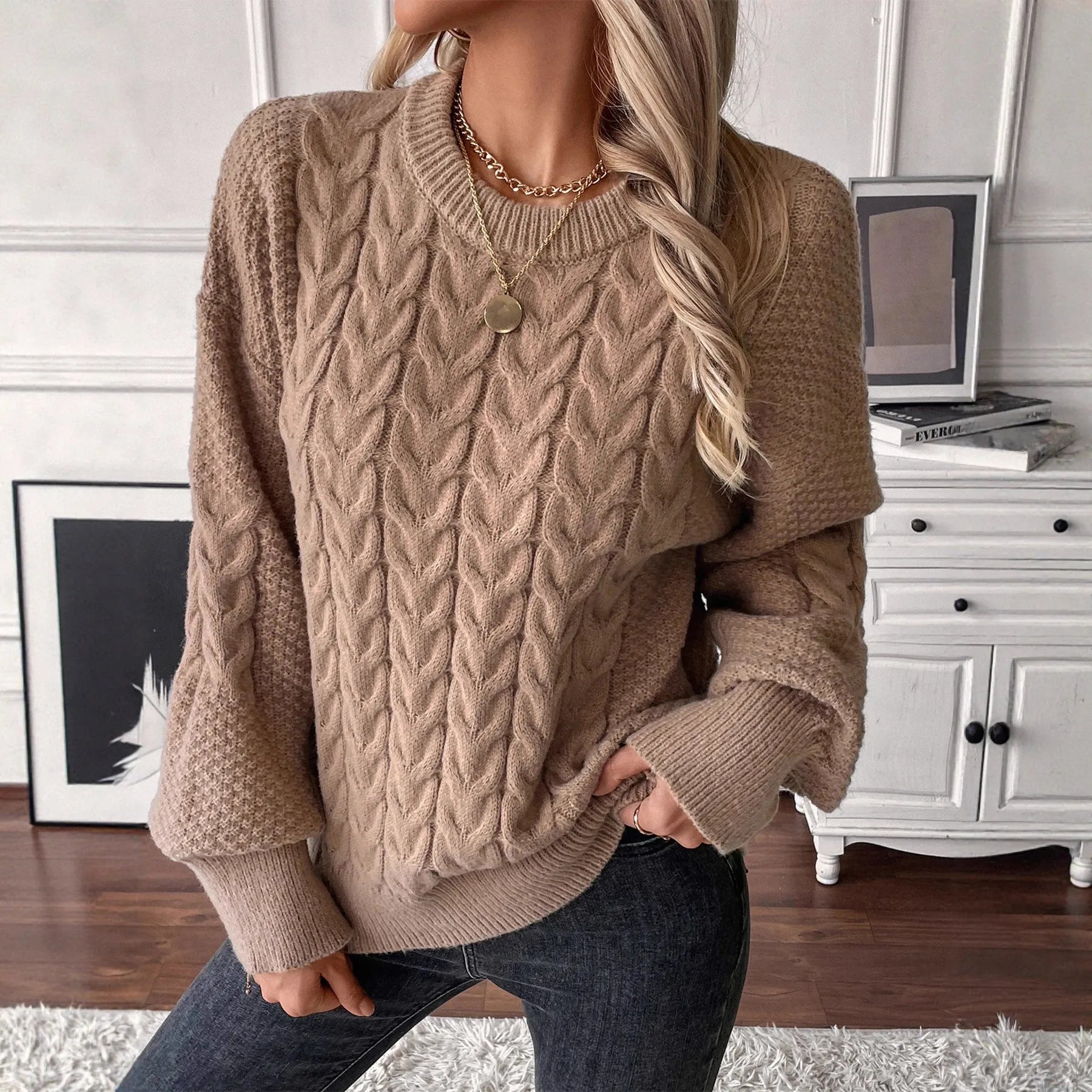 A woman's loose-fit round neck sweater in a solid colour, shown in a casual street fashion style.