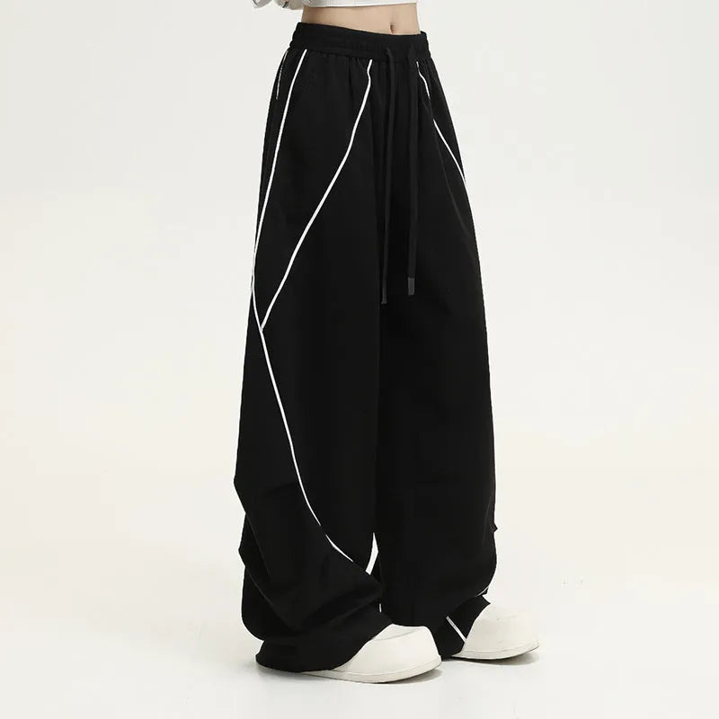 Black pleated hip hop sports pants with stripe pattern showing wide-leg design and mid-waist fit