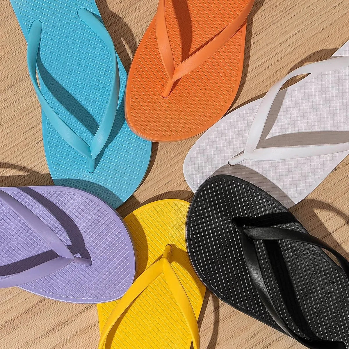 Orange foldable beach slippers with non-slip PVC sole and breathable plastic upper design.
