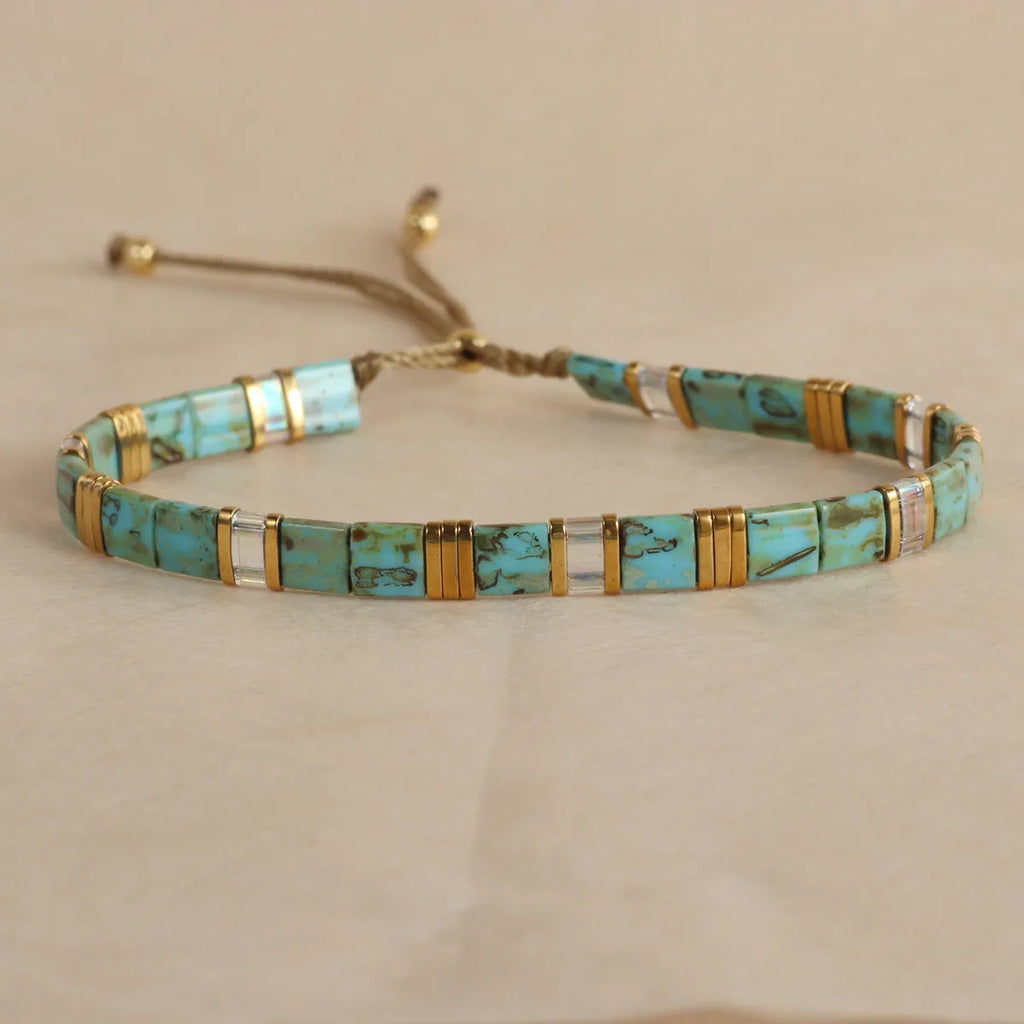 Geometric glass and coloured glaze beaded bracelet in milky white, black, green, blue, or red.