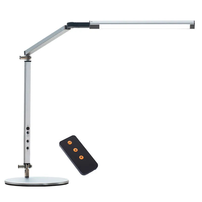 Aluminium LED desk lamp with a stainless steel clip mount and remote control on a wooden desk.