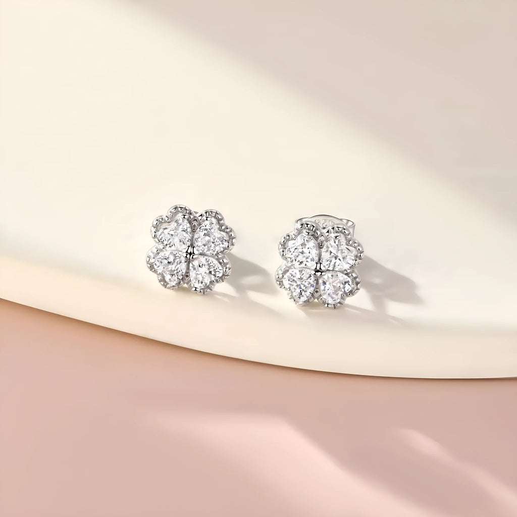 Close-up of women's 925 silver drop earrings with a four-leaf clover charm and heart zircon, in white gold colour.