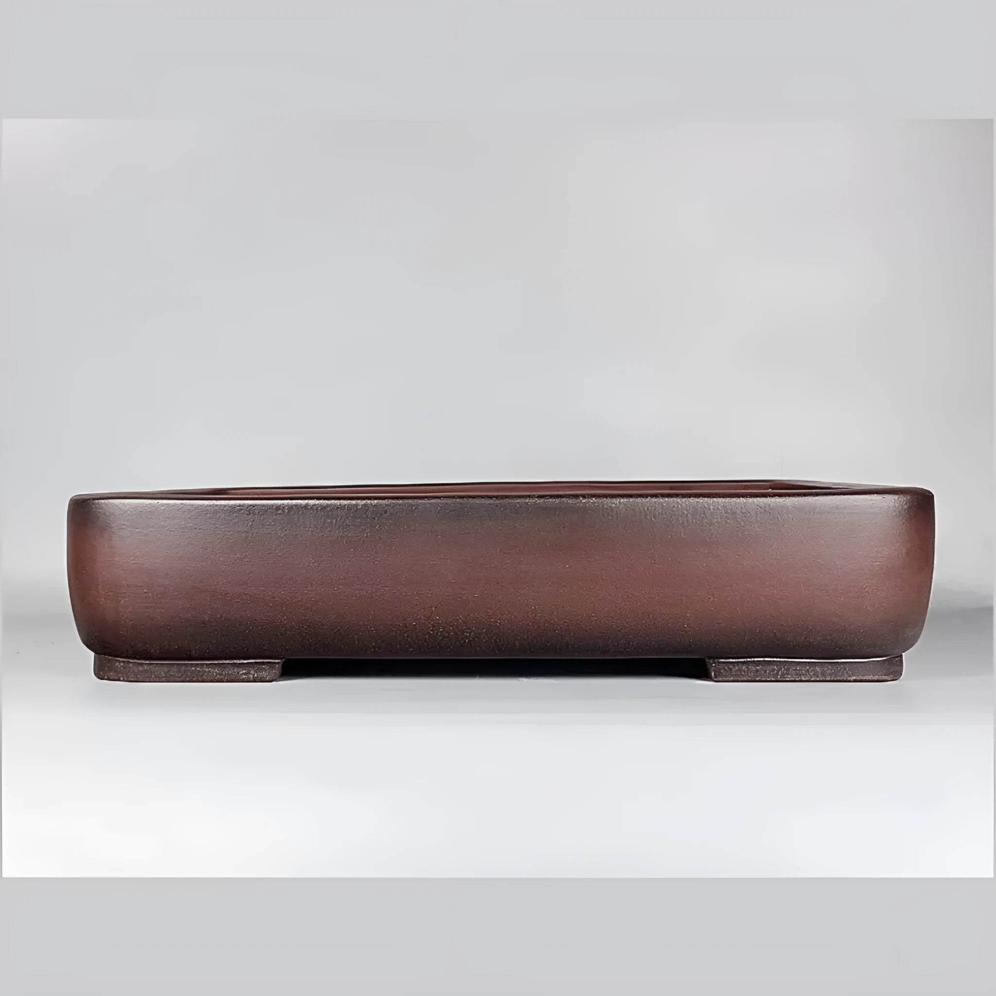 Handmade antique rectangular purple clay flower pot for plants on a tabletop.