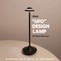 Modern black UFO-shaped rechargeable table lamp with touch-sensitive dimming controls on a wooden desk.