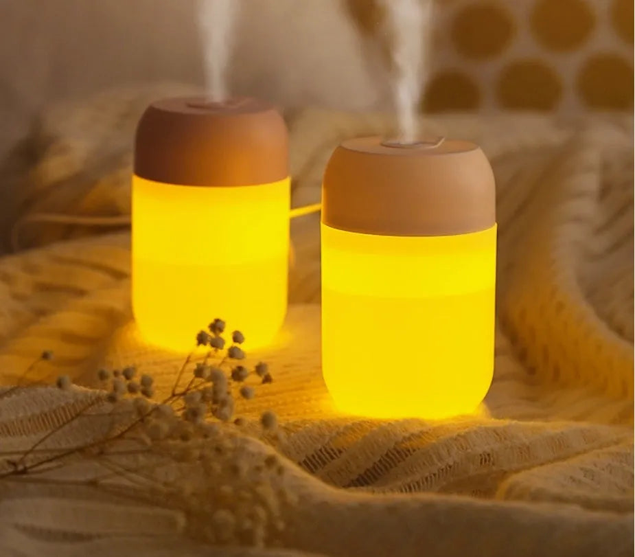 Small white cylindrical USB humidifier with charging cable on table