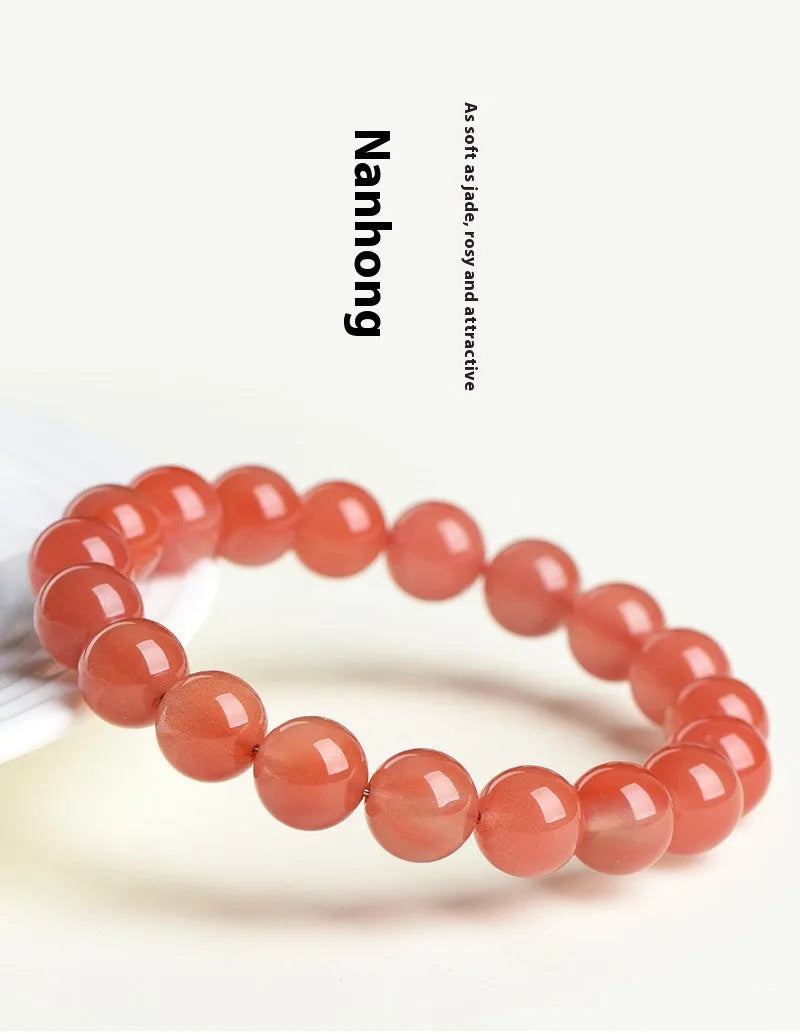 Natural South Cherry Red Agate beaded bracelet on a wrist, showing polished scattered beads on an elastic cord.
