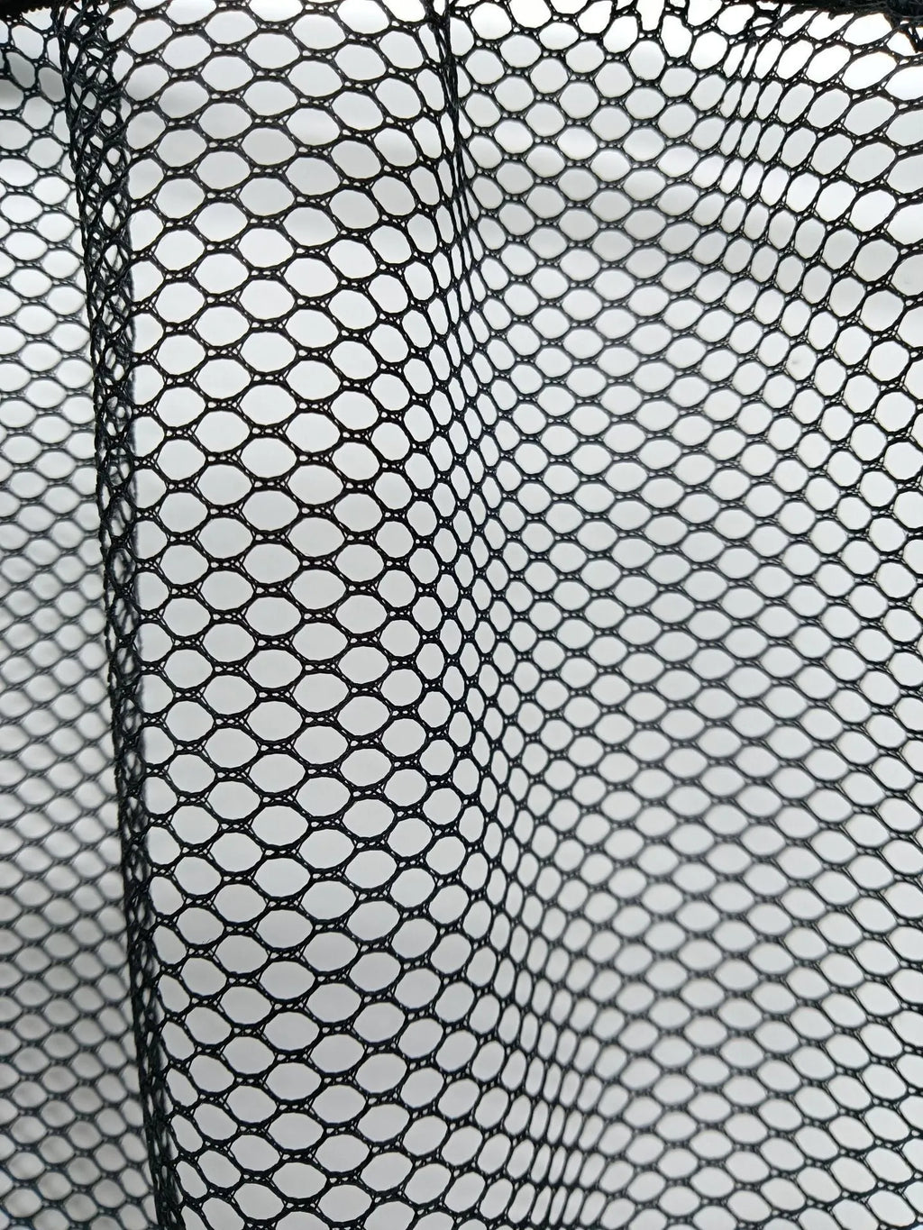 Elasticated grey polyester storage net stretched across a car boot, holding assorted items.