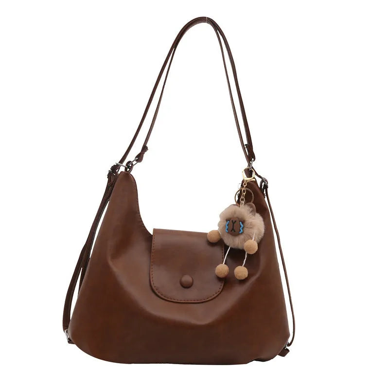 Black PU leather women's single strap shoulder bag showing horizontal square shape and internal mobile phone compartment