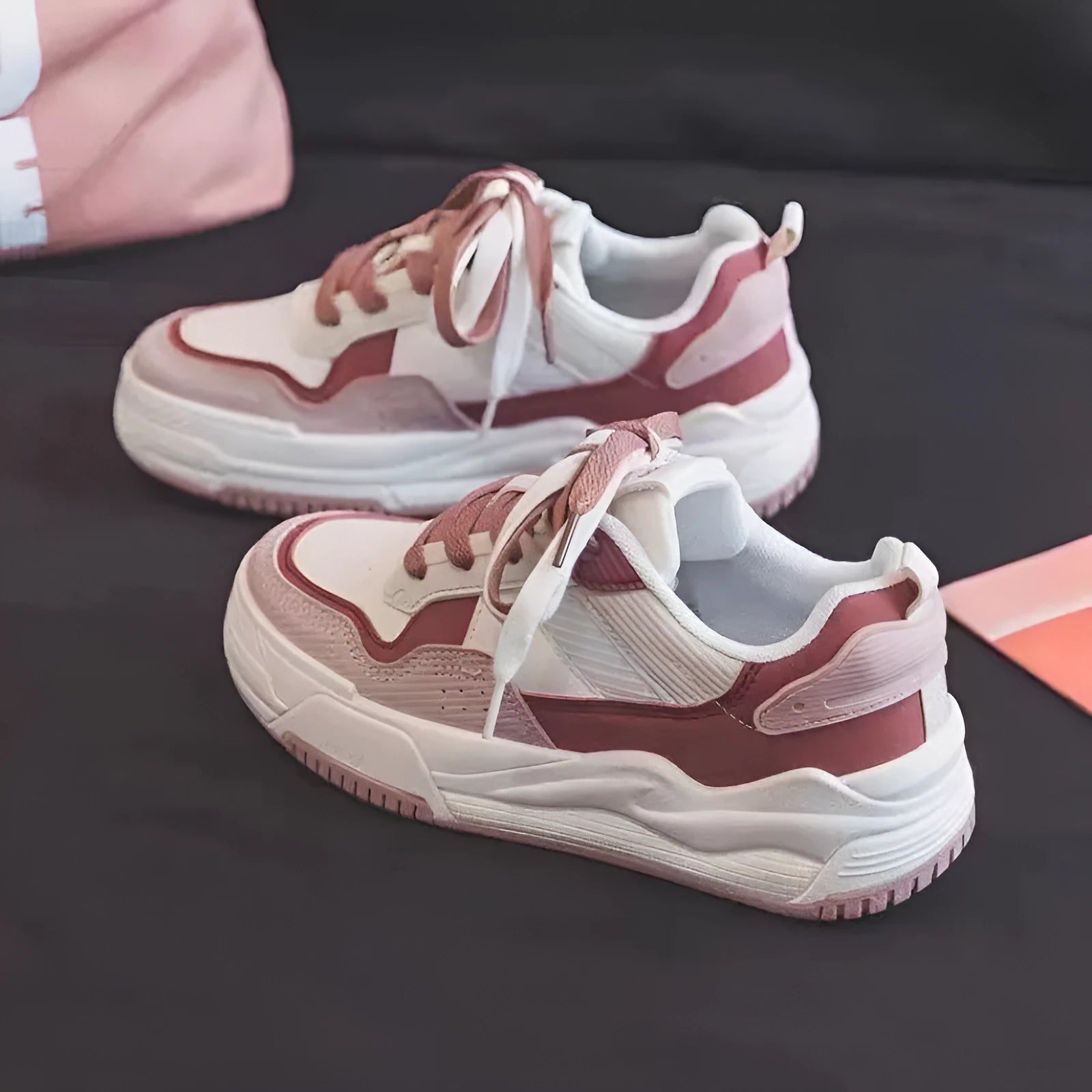 Pink and white low-top sneakers with rubber soles and imitation leather lining