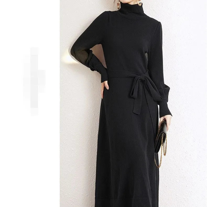A woman wearing a rose red turtleneck long-sleeve knit dress with an elastic waist and loose hem.