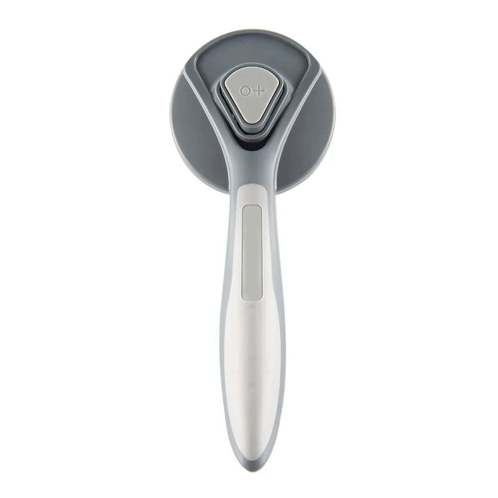 Grey self-cleaning slicker brush for pets with one-click button and comfort-grip handle on a table.
