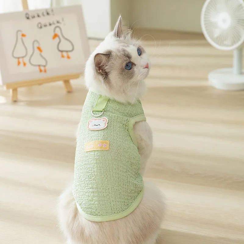 Green cat clothing with a cartoon bear patch, made from hollowed-out knitted fabric.