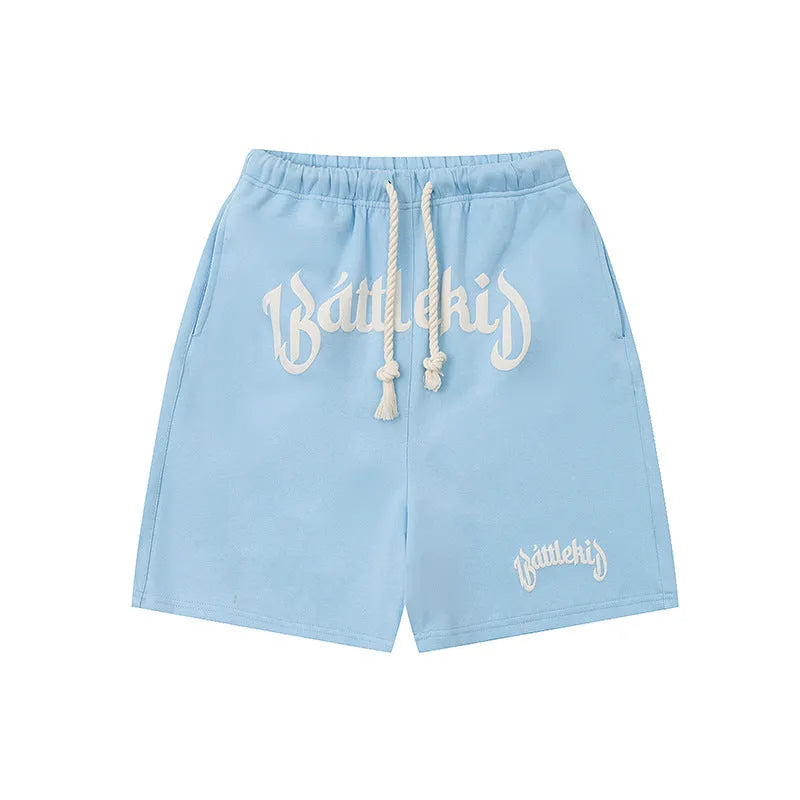 Loose cotton-blend cropped shorts in black, yellow, blue, and grey for street style.