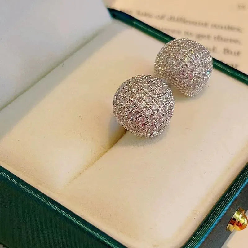 Gold and white drop-shaped geometric earrings with sphere elements and sparkling crystals