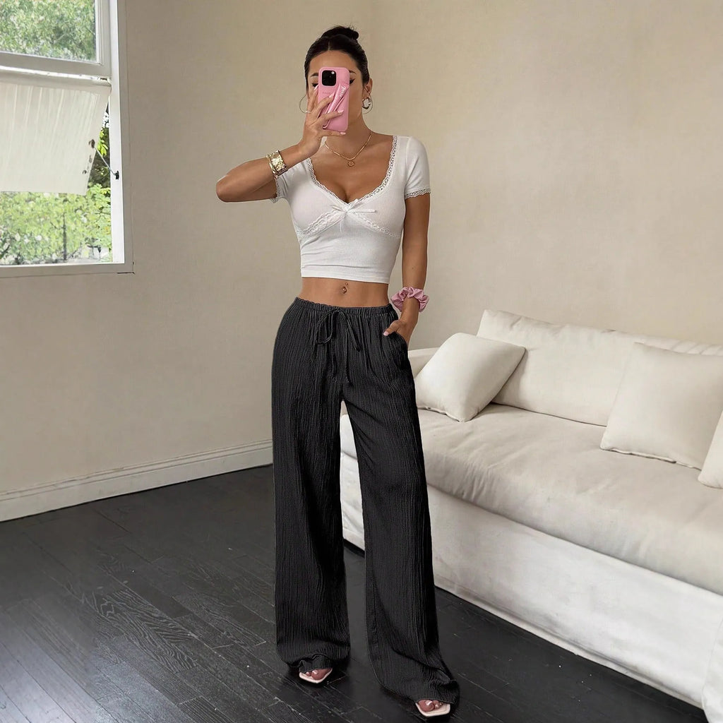 Women's wide-leg trousers with lace-up waist trimming in black or pink colours