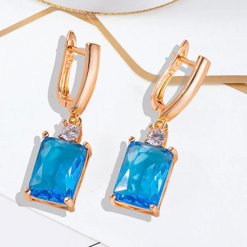 A pair of square gold and silver electroplated copper earrings showing geometric quadrilateral shape.