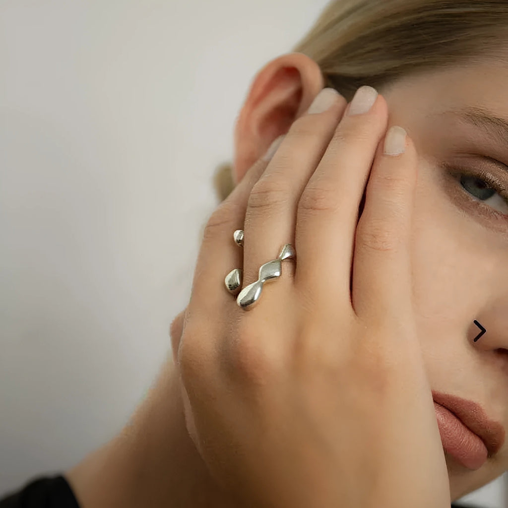 Brass opening ring with spherical element in gold finish on model finger