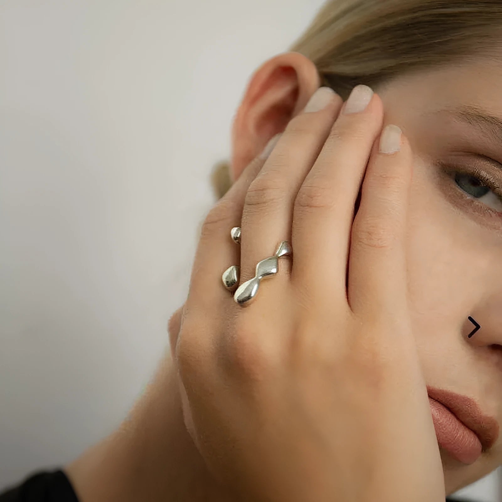 Brass opening ring with spherical element in gold finish on model finger