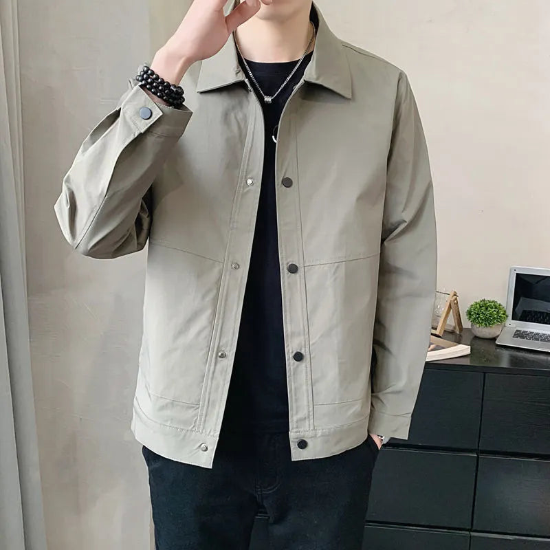 Man wearing a thin, single-layer Korean-style jacket in light grey, showcasing long sleeves and a casual fit.