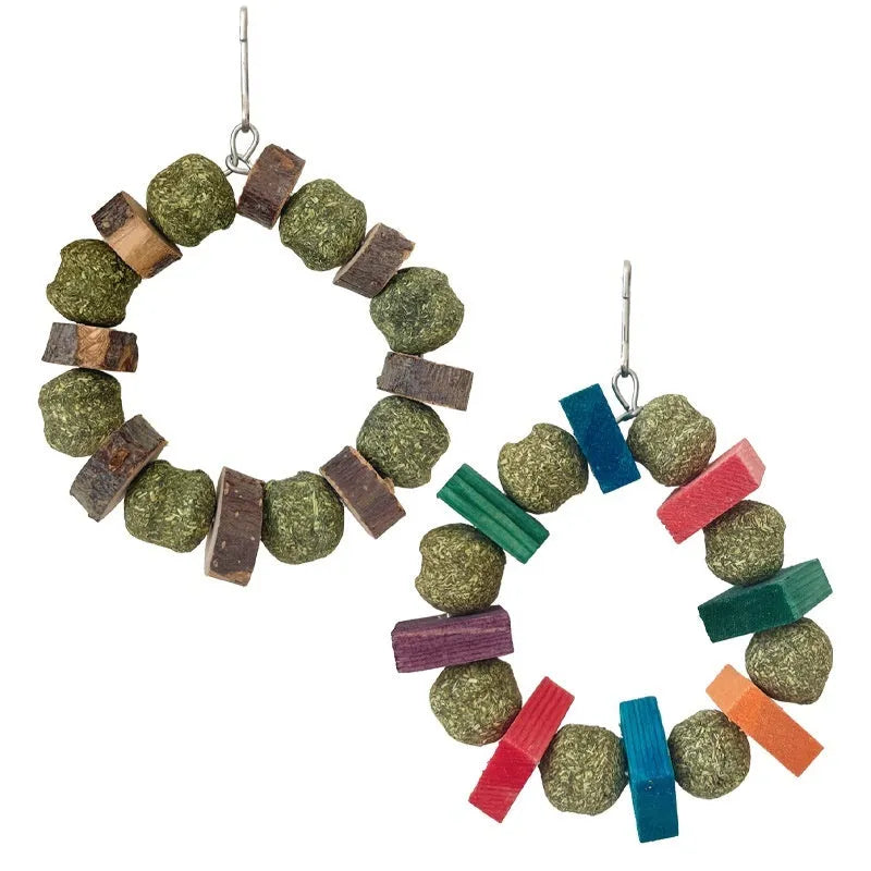 Hamster toy with applewood chew stick and colourful straw ball ring on a white background