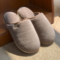 Solid colour PVC plush winter slippers for men and women on a home floor