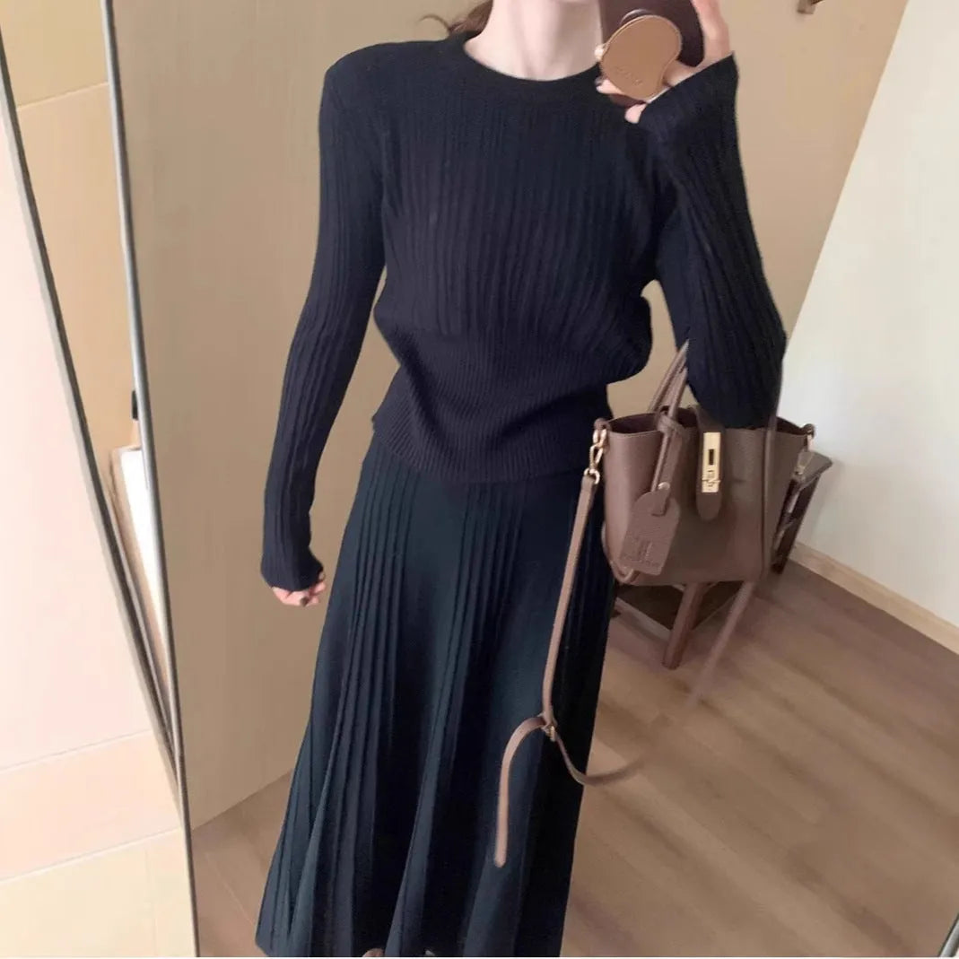 Women's dark grey knitted dress suit set with sweater and skirt showing 3D knit pattern and collage stitching