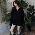 Women's creamy-white cable knit sweater and shorts set with geometric pattern and elastic waistband.