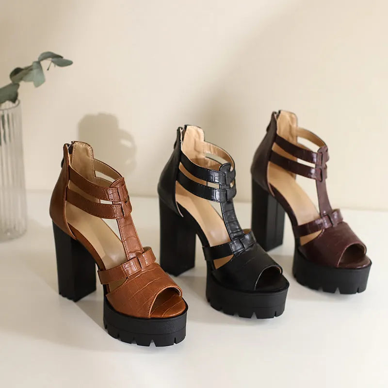 Black platform high heel sandals with round head and back zipper on plain background