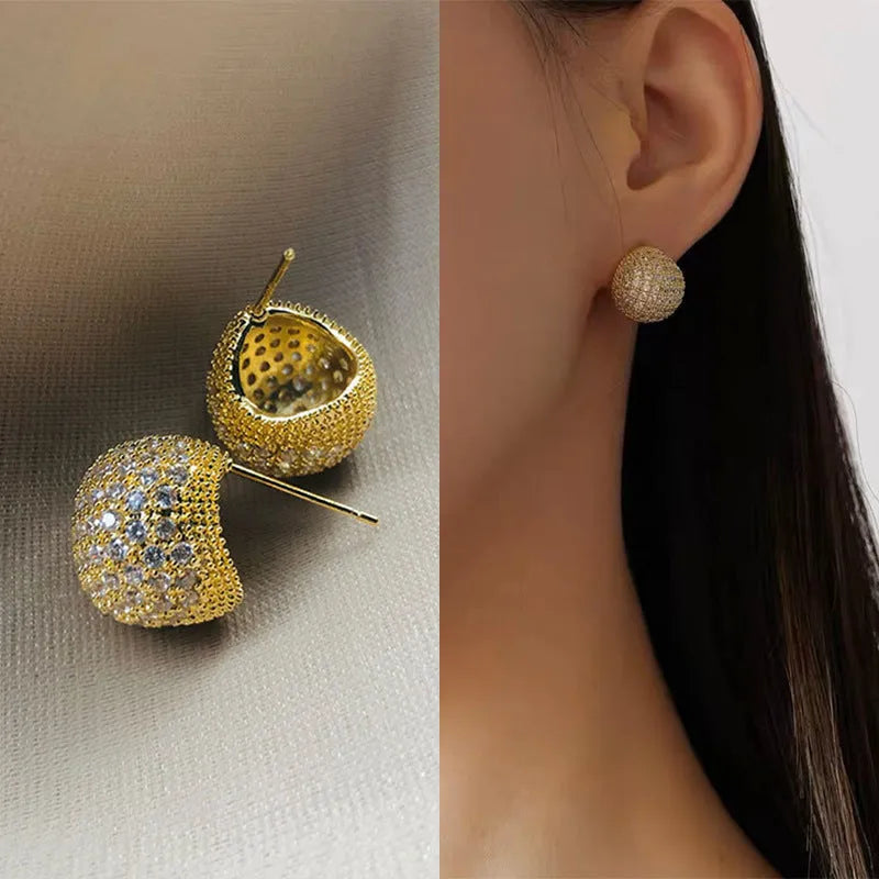Gold and white drop-shaped geometric earrings with sphere elements and sparkling crystals